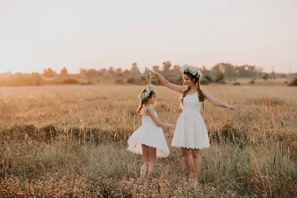 Madre e figlia felici in abiti bianchi stanno girando e hanno gioia e felicità in estate — Foto Stock
