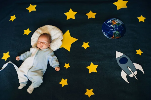 Baba fiú alszik a háttérben a csillagos ég egy rakéta, és a bolygó — Stock Fotó