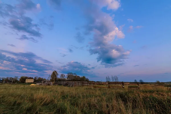 rural landscape with a house in the village in the evening at dusk in autumn