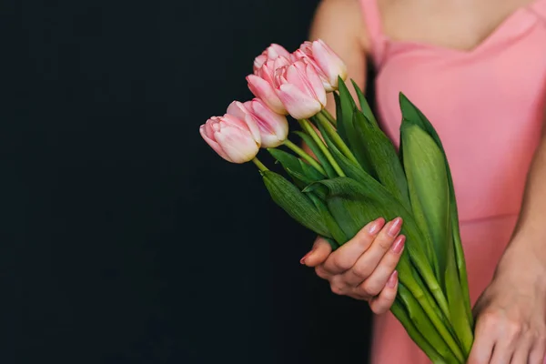 Ramo de tulipanes rosados en las manos de una chica en un vestido — Foto de Stock