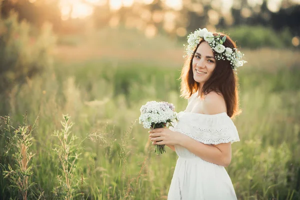 花と夏に花輪の花束と白いドレスを着た白人の幸せな女の子 — ストック写真