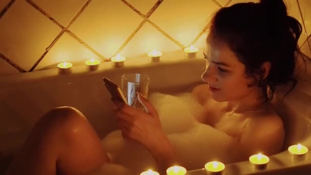 Νεαρή Κοπέλα Χρησιμοποιεί Ένα Smartphone Στο Μπάνιο Για Επικοινωνούν Κοινωνικά — Αρχείο Βίντεο