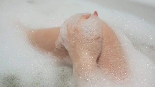 Hermosa chica morena acaricia sexualmente su pierna y canta en el baño con espuma — Vídeo de stock