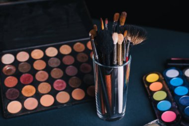 profesyonel makyaj fırçaları renkli göz gölgeler ile bir palet arka plan ayarlamak