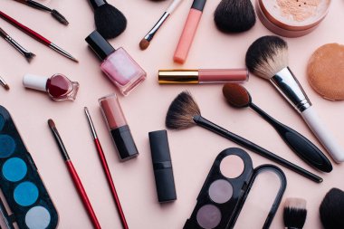 Pembe arka planda kadın kozmetiği ve makyaj seti. Üst görünüm
