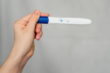bir kızın elinde pozitif gebelik testi
