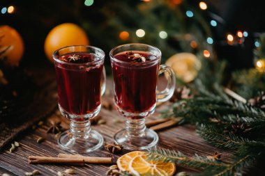 masada Noel dekor ile portakal dilimleri, tarçın çubukları ve baharatlar ile mulled şarap bardak