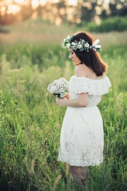 bir buket çiçek ve bir çelenk beyaz elbiseli güzel genç kız