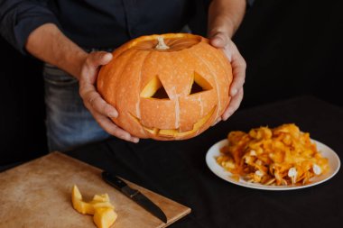 adam Cadılar Bayramı için bir portakal kabak yapar