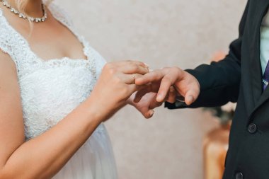 gelin damadın parmağına altın bir alyans koyar