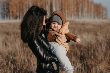 Neşeli mutlu genç anne bebek çocuk çocuk oğlu onun elinde sonbaharında ile