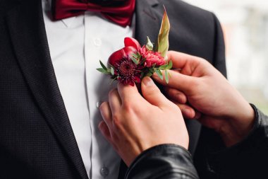 arkadaş damat takım elbise bir boutonniere koyar