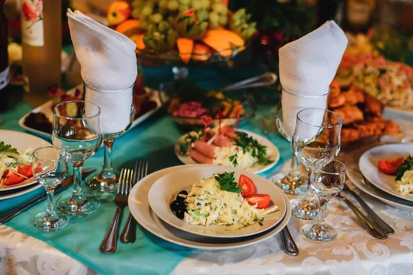 Εορταστικό τραπέζι στο εστιατόριο με πιάτα, ποτήρια και μαχαιροπίρουνα σε λευκό τραπεζομάντηλο — Φωτογραφία Αρχείου