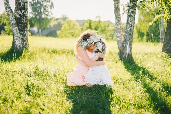 Anya lánya ül a fűben kint a nyári hugs — Stock Fotó