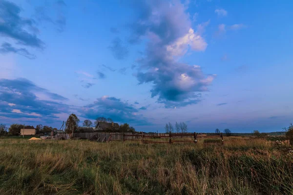 rural landscape with a house in the village in the evening at dusk in autumn