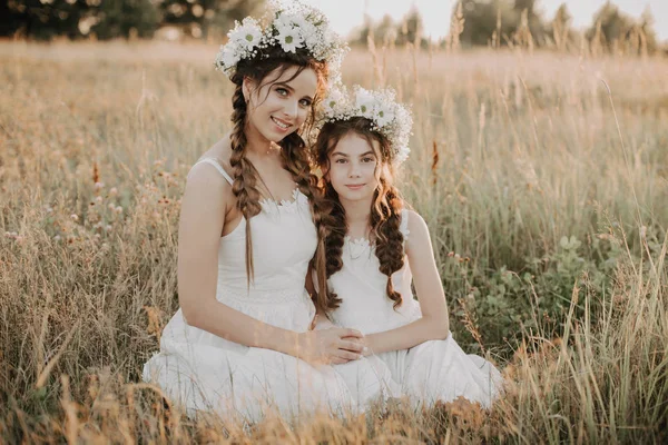 Felice mamma e figlia sorridente e abbracciare l'erba nel campo in estate — Foto Stock