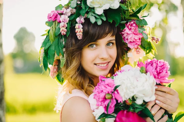çiçek çelenk ve peonies gün güneşli yaz bir buket ile mutlu gülümseyen kız