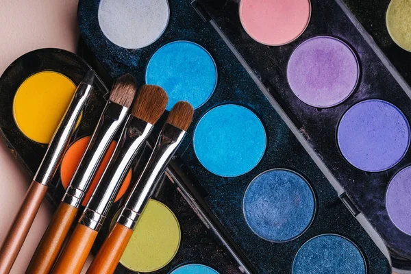 renkli göz gölgeler ile bir palet üzerinde makyaj fırçaları seti