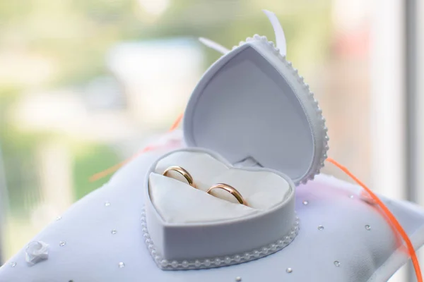 Dos anillos de boda de oro se encuentran en una caja blanca — Foto de Stock