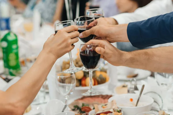 Mains d'un groupe d'amis cliquetis verres de vin et de pain grillé — Photo