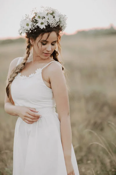 Chica con trenzas y una corona floral en un vestido boho blanco en verano al aire libre — Foto de Stock