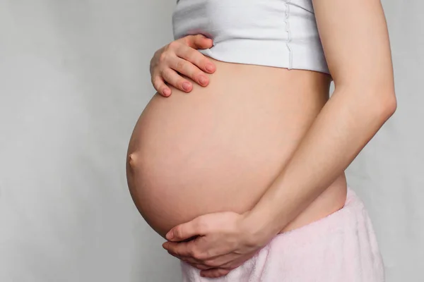 Fille enceinte étreignant son ventre avec ses mains — Photo