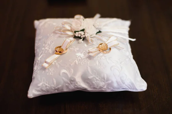 Dwa złote tradycyjne obrączki na białej poduszce — Zdjęcie stockowe