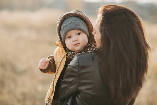 Young mom holds her baby boy son in her arms