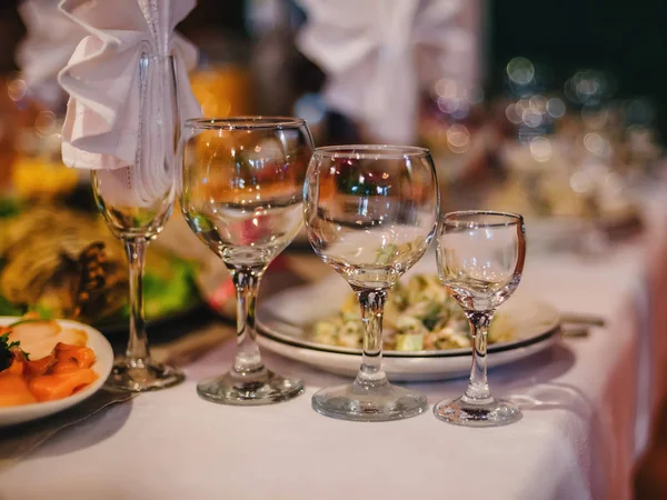 Mesa festiva en el restaurante con platos, vasos y cubiertos sobre un mantel blanco —  Fotos de Stock