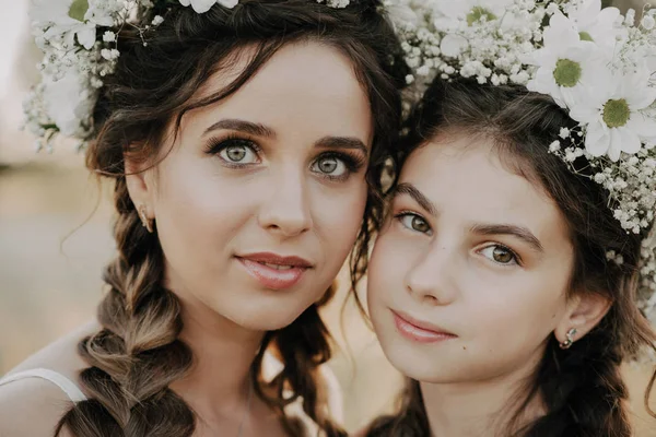 Retrato de mãe branca caucasiana com sua filha com tranças e grinaldas no verão ao ar livre — Fotografia de Stock