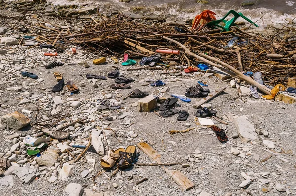 GELENDZHIK, RUSIA - 1 de agosto de 2012: La orilla del mar está llena de basura de zapatos humanos — Foto de Stock