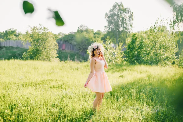 Hermosa chica en un vestido de aspecto caucásico con una corona en la cabeza en un prado — Foto de Stock