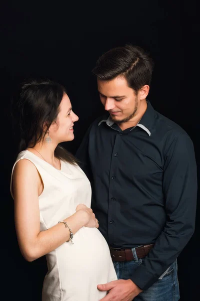 Glückliche schwangere Mädchen und Mann umarmen sich für Bauch. Konzept einer jungen Familie — Stockfoto