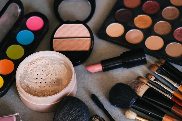 Cosmetica voor vrouwen voor schoonheid en huidverzorging op tafel. Make-up penselen, oogschaduw palet, lippenstift, poeder, mascara — Stockfoto