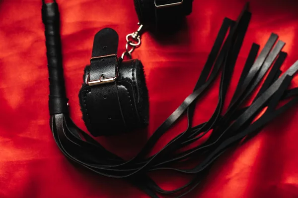 Leather handcuffs and black whip for sex games in bdsm sex — Stock Photo, Image
