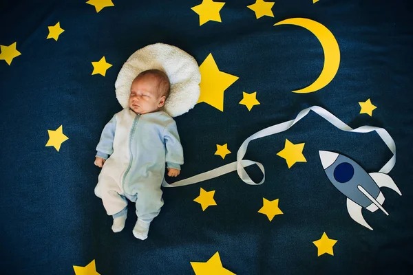 Dormir bébé garçon caucasien apparence sur étoilé espace fond avec fusée — Photo