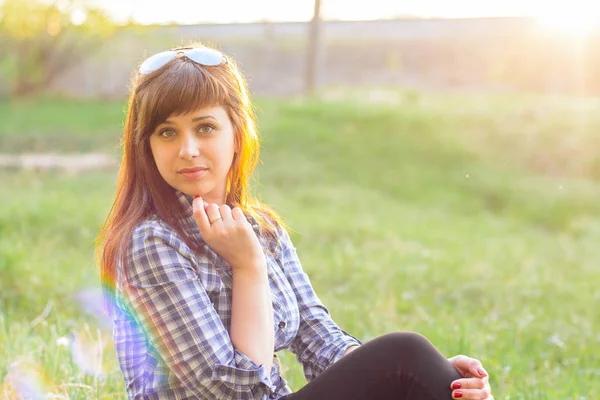 Giovane ragazza che riposa sul campo al tramonto in estate — Foto Stock