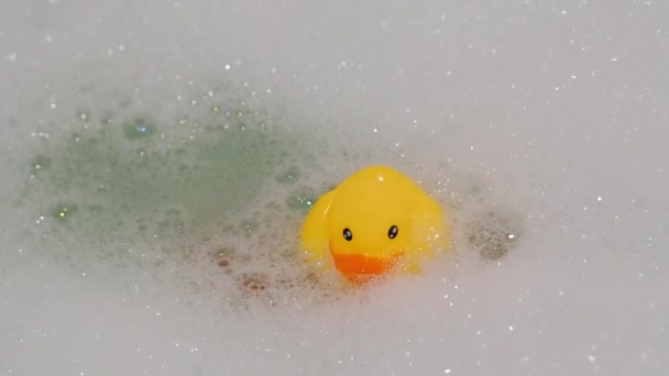 泡とお風呂に黄色いアヒルを保持する手 — ストック動画