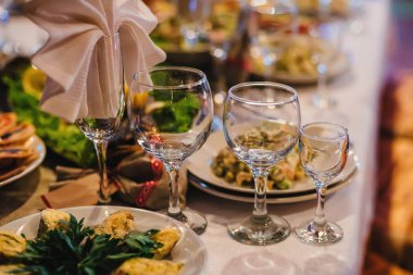beyaz bir masa örtüsü üzerinde tabak, gözlük ve Çatal ile restoranda şenlikli masa