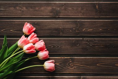 kahverengi ahşap bir masa üzerinde pembe Lale çiçek buketi.