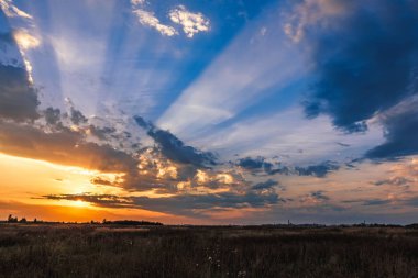 sonbaharda akşam mavi gökyüzünde güneşin turuncu ışınları ile güzel renkli gün batımı