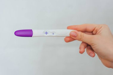 bir kızın elinde pozitif gebelik testi