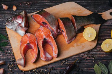 Taze alabalık ahşap bir gemide parçalar halinde kesin. Çiğ kırmızı balık