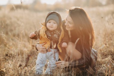 Sonbaharda yürüyüş için mutlu genç aile. Anne onun bebek oğlu erkek ile