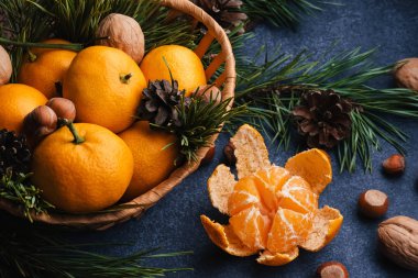 Noel dalları ve kozalaklarla süslenmiş fındık, ceviz ve mandallar.