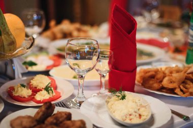 beyaz bir masa örtüsü üzerinde tabak, gözlük ve Çatal ile restoranda şenlikli masa