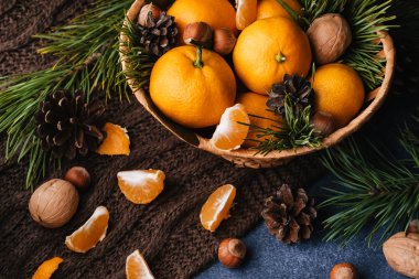 Çam kozalaklarıyla süslenmiş mandalina, ceviz ve fındık