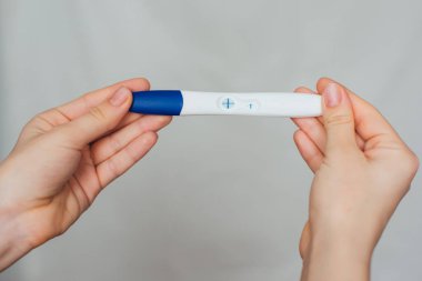 bir kızın elinde pozitif gebelik testi