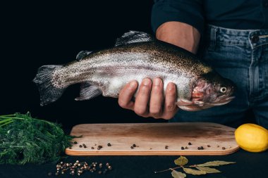 Şefin gökkuşağı alabalık elleri Board baharatlar üzerinde yakın çekim