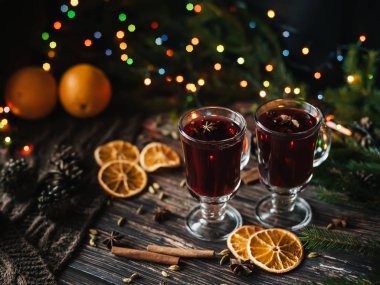 Noel mulled şarap portakal dilimleri, tarçın ve diğer baharatlar ile Noel ağacı ahşap bir masa üzerinde